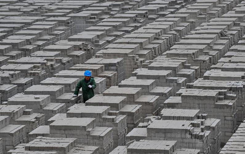 一名工人在粉煤灰砖场上巡查(5月21日摄).